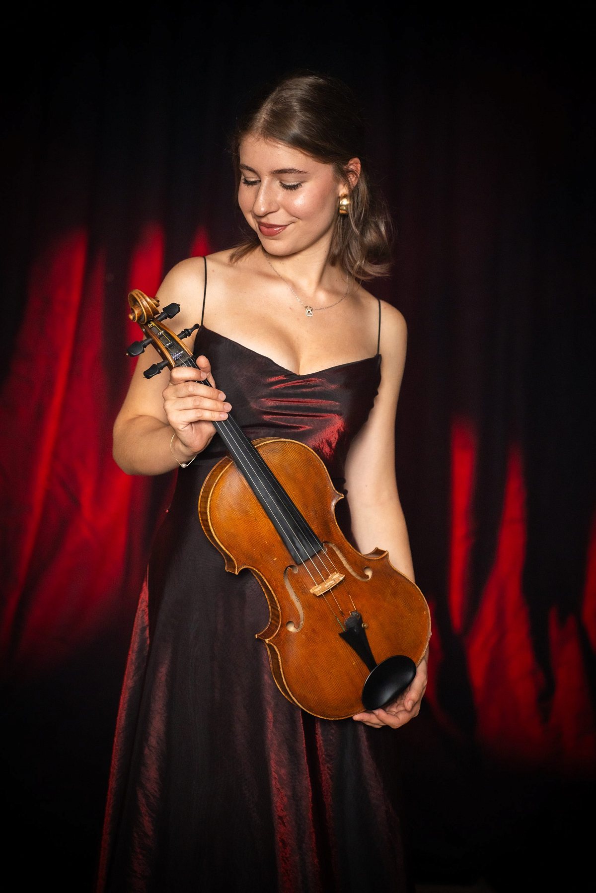 Mottoshooting mit Violine vor rotem Vorhang